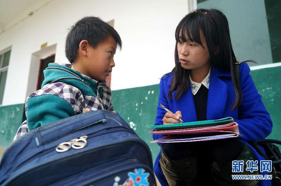 Xu Rui writes down the account number from fixed sponsors for a student at a primary school in the Putang Village of east China's Jiangxi Province on January 26, 2015. [Photo: Xinhua]
