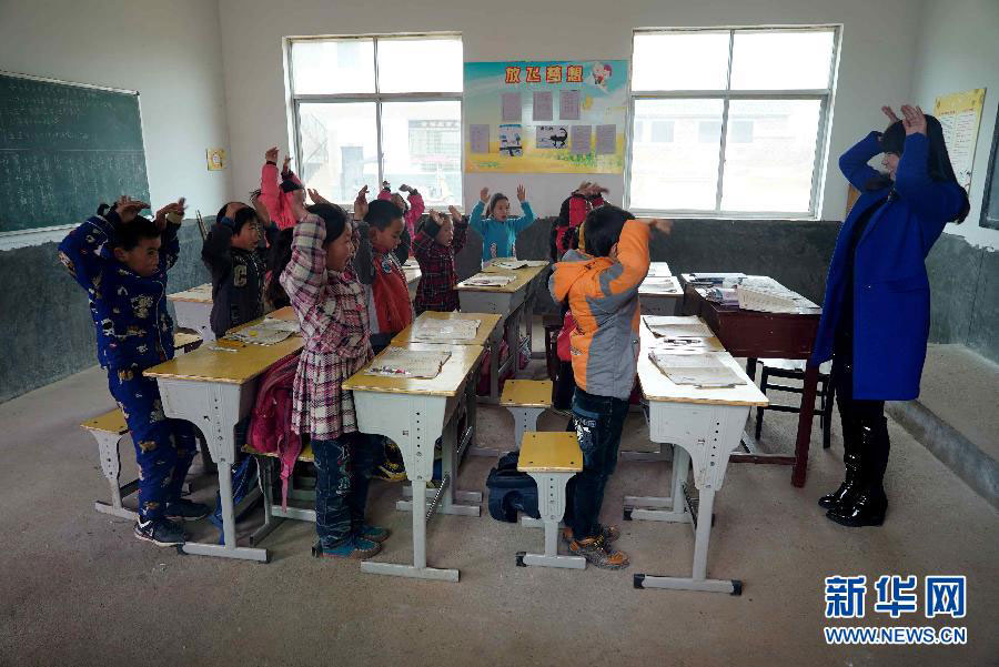 Xu Rui plays with students in class at a primary school in the Putang Village of east China's Jiangxi Province on January 26, 2015. [Photo: Xinhua]