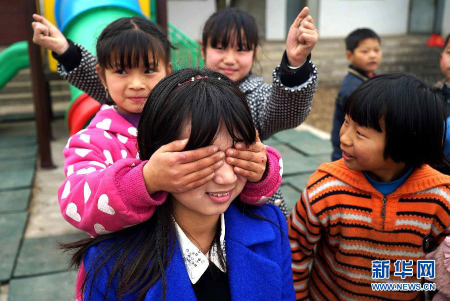 Xu Rui plays with students during class break at a primary school in the Putang Village of east China's Jiangxi Province on January 26, 2015. [Photo: Xinhua]