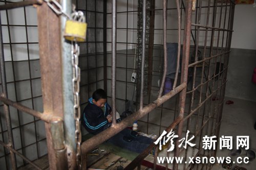 Xiao Wang, a 12-year-old boy who suffers Attention deficit hyperactivity disorder (ADHD), plays inside an iron cage.[Photo/xsnews.cc] 