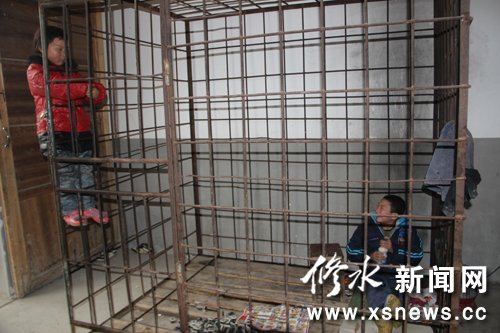 Xiao Wang, a 12-year-old boy who suffers Attention deficit hyperactivity disorder (ADHD), plays inside an iron cage.[Photo/xsnews.cc]