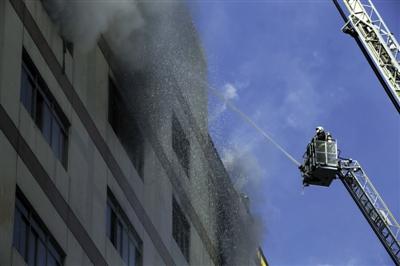 Firefighters are putting out the fire using a water cannon in front of a department store in Beijing on Jan 30, 2015. [Photo: the Beijing News]