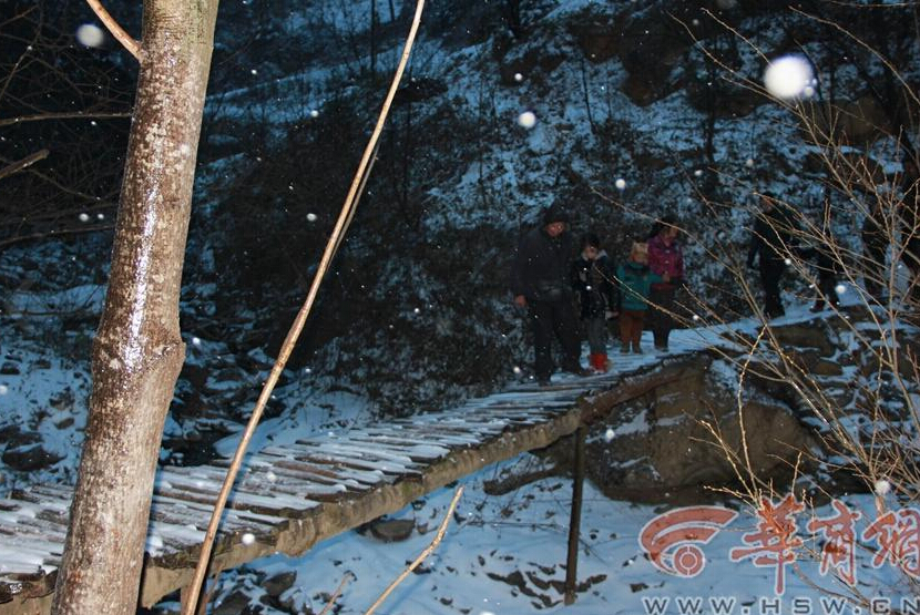 Elementary students and their parents walk on a snow-covered mountain road to school in Guanyin township, Zhenba county, Northwest China’s Shaanxi province, Jan 29, 2015.[Photo/HSW.cn] 