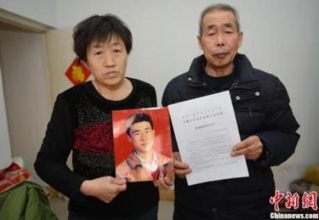 Huugjilt's parents hold a decision on their compensations from the government on Dec. 30, 2015. [Photo / Chinanews.com] 