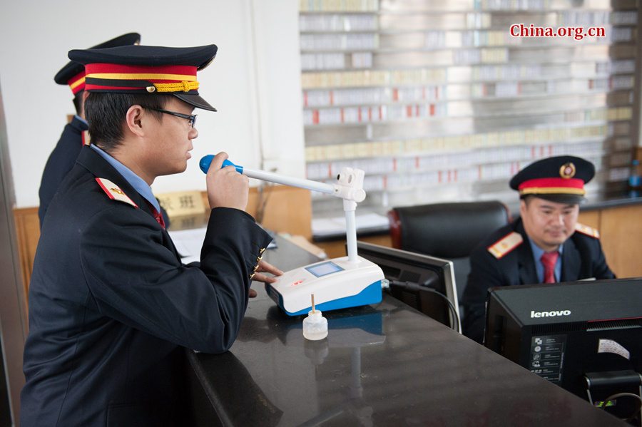 Song Jian (R2) and Ding Hailong take an alcohol test prior to their daily duty. Song says they also have to take a test when they return from duty to ensure that train drivers do not drink alcohol when driving. [Photo by Chen Boyuan / China.org.cn]