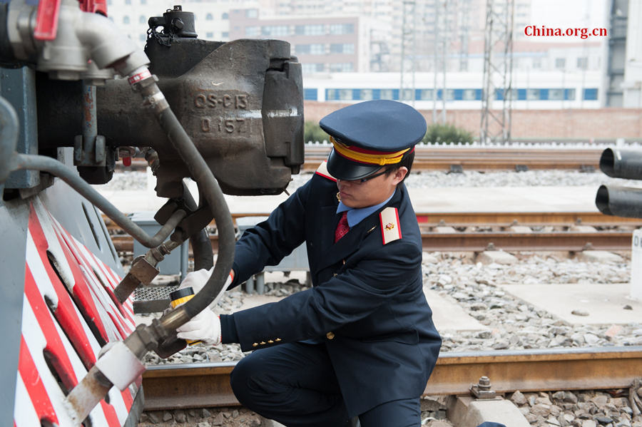 Song Jian performs a visual inspection before the two drivers board the locomotive. [Photo by Chen Boyuan / China.org.cn]