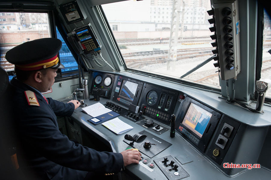 The locomotive&apos;s chief engineer and driver Ding Hailong checks all meters before setting the locomotive in motion. [Photo by Chen Boyuan / China.org.cn]