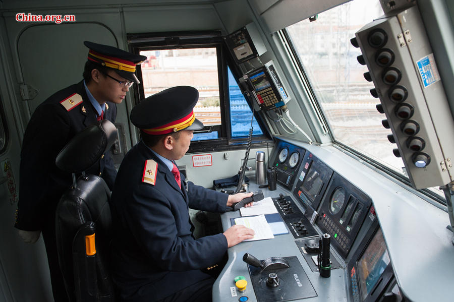 Song Jian and Ding Hailong make sure all the meters on the locomotive are displaying correctly before Ding can set the train in motion. [Photo by Chen Boyuan / China.org.cn.cn]