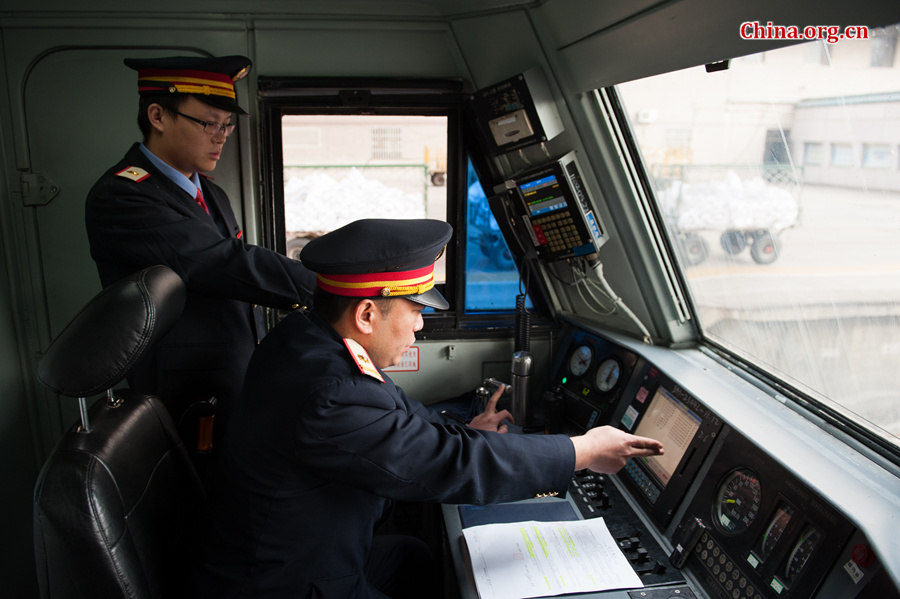 As the train reaches Beijing West Station to allow passengers to board, Song Jian (R) and Ding Hailong check all the meters again. [Photo by Chen Boyuan / China.org.cn]