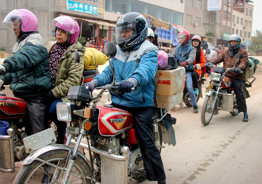  A photo taken on Tuesday, Feb 3, 2015 shows migrant workers in south China's Pearl River Delta cities return home on motorcycles through south China's Guangxi Zhuang Autonomous Region for the Spring Festival during the country's busiest travel season.[Photo by Gan Hanshen/asianewsphoto]