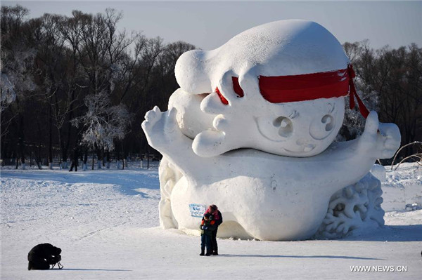 Visitors take photos in front of a snow sculpture on the Sun Island in Harbin, capital of Northeast China's Heilongjiang province, Feb 5, 2015. [Photo/Xinhua] 
