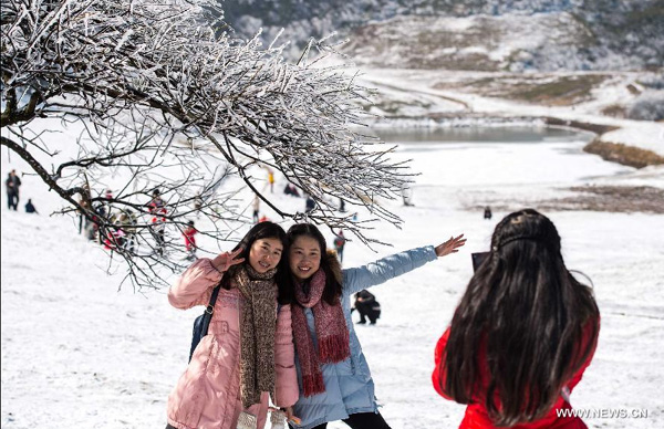 Tourists pose for photos in the snow-covered Jinfo Mountain scenic spot of southwest China's Chongqing, Feb 6, 2015. Since winter began, scenic spots like Jinfo Mountain where people can enjoy snow scenery has attracted a lot of tourists. [Photo/Xinhua]