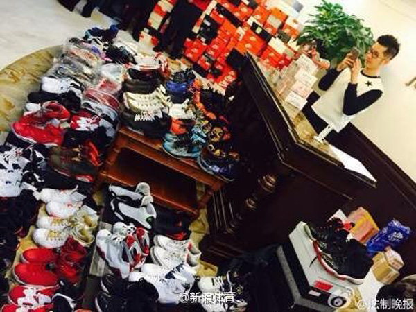 A member of staff at the pawn shop photographs sneakers Mick pawned in Beijing on Sunday. [Photo/Sina Weibo] 