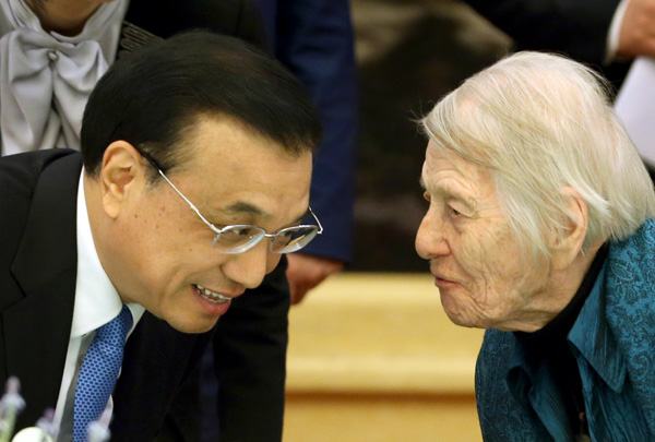 Premier Li Keqiang chats with Canadian educator Isabel Crook at the Great Hall of the People in Beijing on Tuesday after a meeting with more than 60 foreign experts. Crook, who celebrated her 100th birthday in December and has devoted most of her life to English-language teaching in China, has attended many meetings with Chinese leaders. [Photo / China Daily] 