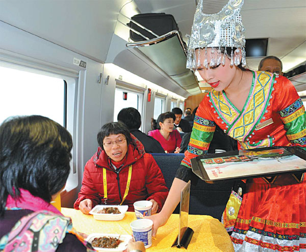 A train attendant wearing the traditional clothing of the Miao ethnic group serves passengers on the Guiyang-Guangzhou high-speed railway in December. Cao Ning / For China Daily 