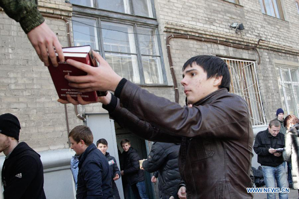 People receive humanitarian aid in the street in Donetsk, eastern Ukraine, Feb. 15, 2015. Conflicting sides in Ukraine observed ceasefire at midnight Sunday as written in the Minsk peace agreement.