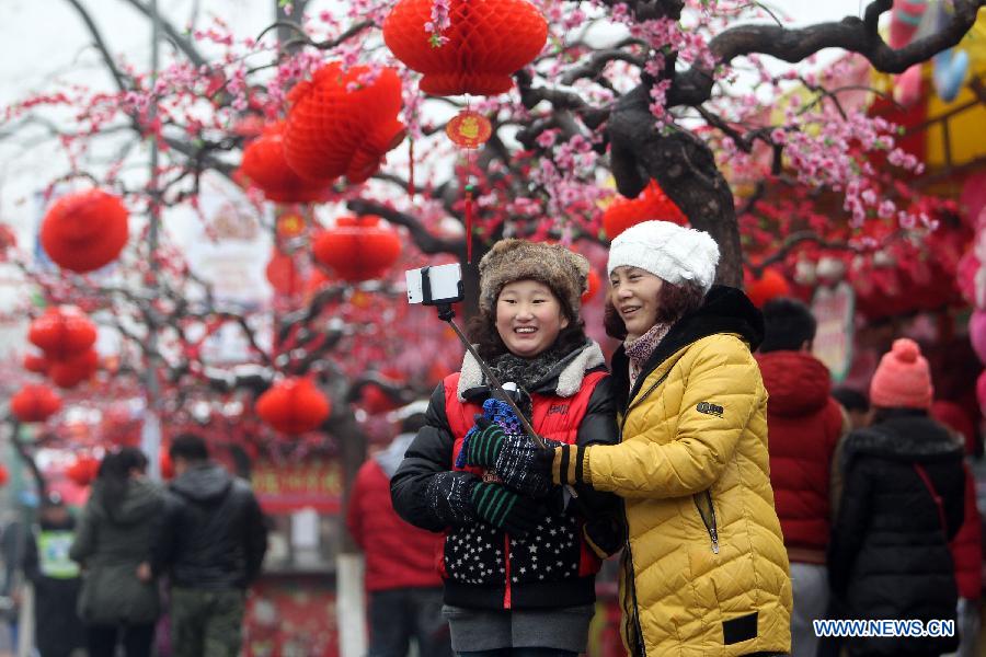 People take selfie at the 32nd Longtanhu temple fair in Beijing, capital of China, Feb. 21, 2015. Chinese people nationwide attend various festivites on Saturday, the fourth day of this year's Spring Festival holiday. [Photo/Xinhua] 