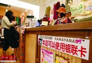 日本冲绳一家商场为吸引中国游客购物，贴出可以使用银联卡消费的标识。(资料图片)