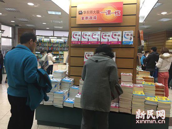 Parents browse through piles of the supplementary textbook 'One Lesson, One Exercise (yi ke yi lian)' in a bookstore in Shanghai on Feb. 26, 2015. [Photo: xinmin.cn]