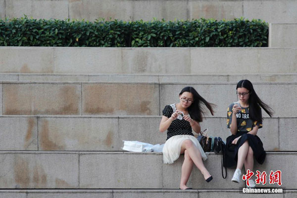 Two women in lightweight dresses take a break. [Photo/chinanews.com]