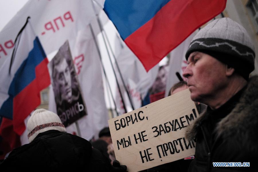 A man holds a banner says 'i am not going to forget and forgive' during the rally in memory of murdered Russian opposition leader Nemtsov who was killed on Saturday in the center of Moscow, Russia, on March. 1, 2015. According to local media, about 10,000 people participate the rally. [Photo/Xinhua] 