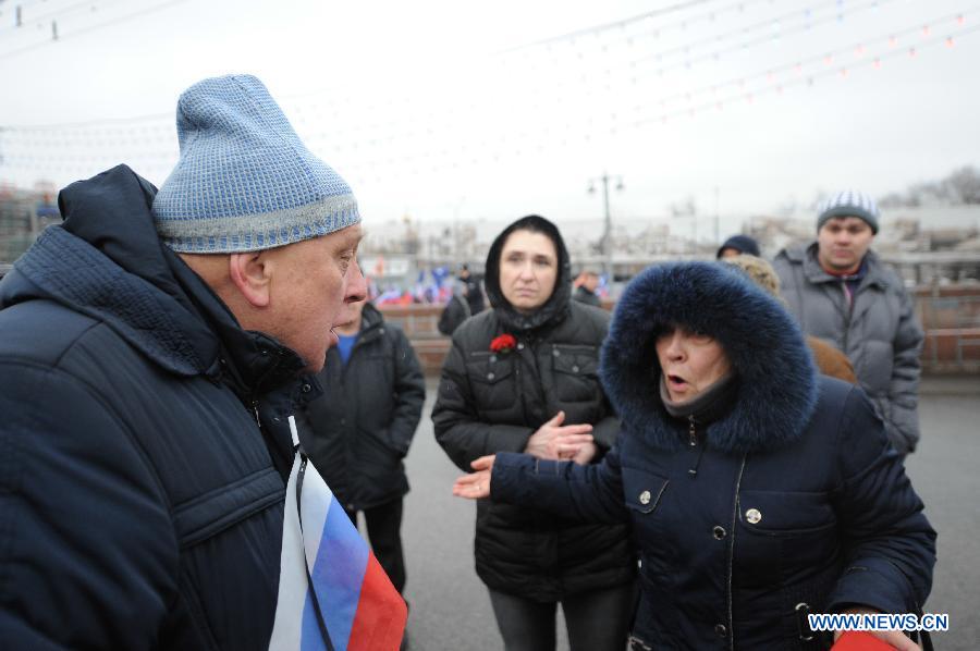 A man and woman argue on political opinions during the rally in memory of murdered Russian opposition leader Nemtsov who was killed on Saturday in the center of Moscow, Russia, on March. 1, 2015. According to local media, about 10,000 people participate the rally. [Photo/Xinhua] 