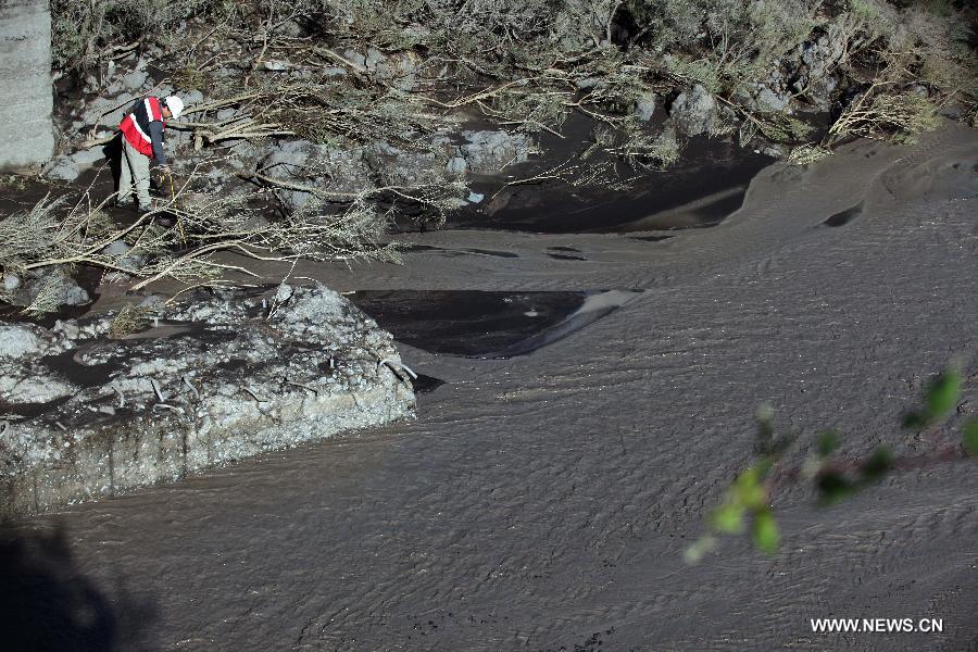 A person watches an ash river created by the eruption of the Villarrica Volcano, located at 18km south of Pucon, and 128km southeast of Temuco, Chile, during the early hours of March 3, 2015. The central and regional authorities issued a Red Alert, and informed that the Villarrica Volcano has considerably increased its activity. According to the local press the volcano registered an eruption at 3 a.m. local time, urging the immediate evacuation of 3,385 people. 