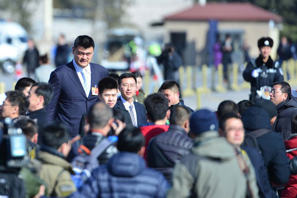 Dozens of reporters try to get quotes from Yao Ming, who is a CPPCC member, on Tuesday. [Photo/Xinhua]