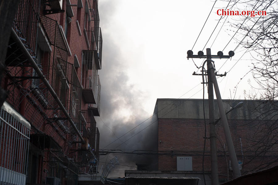 A building catches fire on Thursday, March 5, the traditional Chinese Lantern Festival. The building, according to people who live nearby, is used as a warehouse of Gehua, Beijing&apos;s local cable TV service provider, and the burning rubber from the cable gives out a strong black smoke. [Photo by Chen Boyuan / China.org.cn]