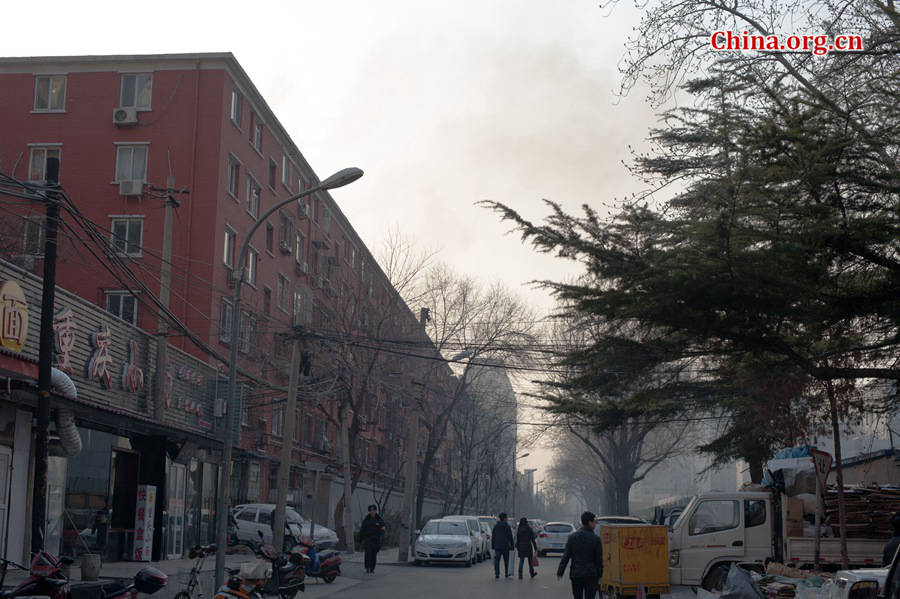 A building catches fire on Thursday, March 5, the traditional Chinese Lantern Festival. The building, according to people who live nearby, is used as a warehouse of Gehua, Beijing&apos;s local cable TV service provider, and the burning rubber from the cable gives out a strong black smoke. [Photo by Chen Boyuan / China.org.cn]