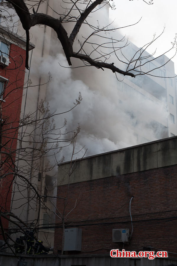 A building catches fire on Thursday, March 5, the traditional Chinese Lantern Festival. The building, according to people who live nearby, is used as a warehouse of Gehua, Beijing&apos;s local cable TV service provider, and the burning rubber from the cable gives out a strong black smoke. [Photo by Chen Boyuan / China.org.cn]