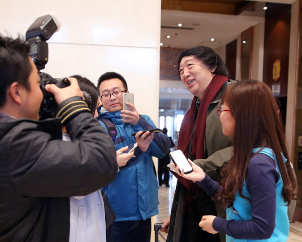 Feng Jicai, writer and CPPCC member, is surrounded by reporters as he registers for the annual session on Monday. Jiang Dong /China Daily