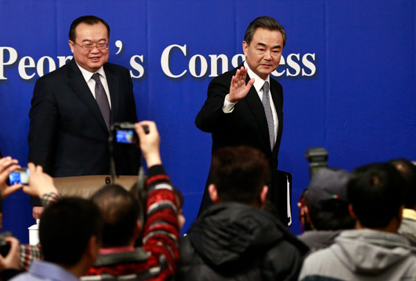 Foreign Minister Wang Yi waves to the media upon his arrival for a news conference in Beijing on Sunday. [Photo/China Daily]