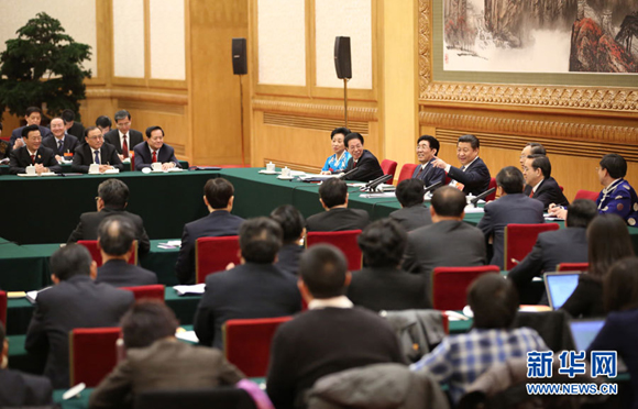 Chinese President Xi Jinping (back, 4th R), also general secretary of the Communist Party of China (CPC) Central Committee and chairman of the Central Military Commission, joins a panel discussion with deputies to the 12th National People's Congress (NPC) from northeast China's Jilin Province during the third session of the 12th NPC, in Beijing,March 9, 2015. [Xinhua/Lan Hongguang]