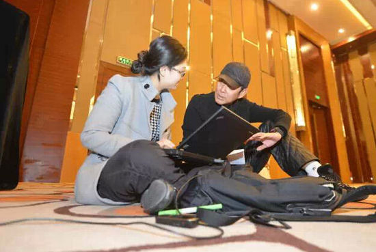 Chen Daoming discusses with a journalist about her story on his proposal. [Photo: Xinhua]