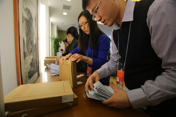  Staff members in the secretarial department of the National People's Congress collect motions from deputies. As of noon on Tuesday, 54 more motions had been submitted than during last year's session. WANG JING/CHINA DAILY