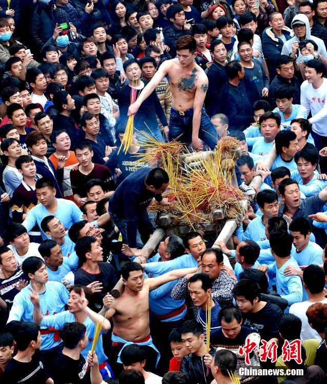 3月12日，羊年农历正月廿二，广东省汕头市澄海区盐灶村举行一年一度传统“拖神偶”民俗活动。轮值抬“神”游行的青壮年在沐浴净身后，把神偶缚在神轿里抬着游行。而想要“拖神偶”的人则紧跟游行队伍，伺机冲上前将神偶拖倒，自己爬上神轿。盐灶“拖神偶”民俗活动历史悠久，是当地群众祈求来年丰收富足的独特方式。[中新社 陈奕享 摄]