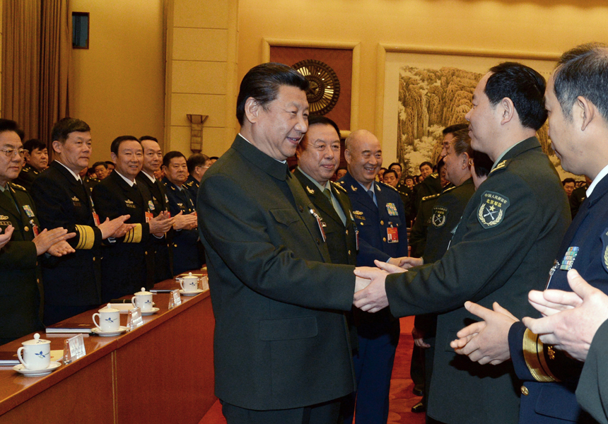 Chinese President Xi Jinping (C), also general secretary of the Communist Party of China (CPC) Central Committee and chairman of the Central Military Commission, shakes hands with deputies to the 12th National People's Congress (NPC) from the People's Liberation Army (PLA) and joins a plenary meeting of the PLA delegation during the third session of the 12th NPC in Beijing, capital of China, March 12, 2015.