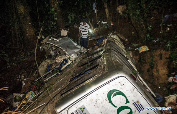 A man searches for the bodies at the site where a tourist bus plunged into a ravine in the state of Santa Catarina, Brazil, on March 15, 2015. At least 43 people possibly died and several others were wounded after a tourist bus plunged 400 meters into a ravine in Santa Catarina province in southern Brazil Saturday afternoon.