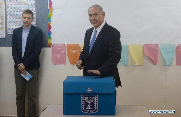 Israeli Prime Minister Benjamin Netanyahu (R) casts his ballot at a polling station during the parliamentary election in Jerusalem, on March 17, 2015. Israel held parliamentary election on Tuesday. 