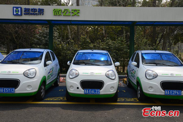 Electric cars, used as 'mini buses', are parked near a subway station in Hangzhou, East China's Zhejiang province, March 17, 2015.[Li Chenyun/China News Service] 