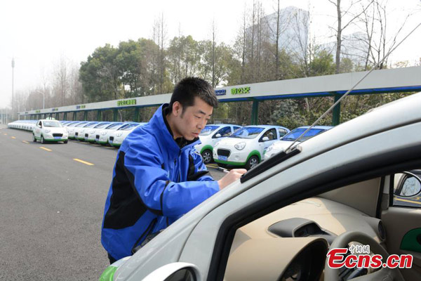 Electric cars, used as 'mini buses', are parked near a subway station in Hangzhou, East China's Zhejiang province, March 17, 2015. [Li Chenyun/China News Service] 