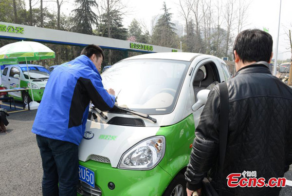 Electric cars, used as 'mini buses', are parked near a subway station in Hangzhou, East China's Zhejiang province, March 17, 2015.[Li Chenyun/China News Service] 