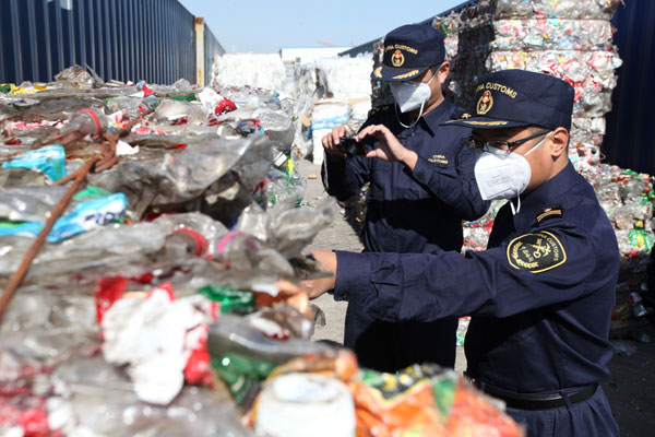 Customs officers in Qingdao, Shandong province, find medical waste among imported solid waste on Oct 15. Medical waste is considered dangerous, and imports of it are banned. [Photo by Liu Hailong / Asianewsphoto] 