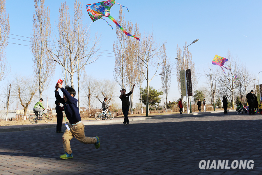 3月21日,一位小朋友拿着风筝迎风奔跑.千龙网记者王璟玥摄