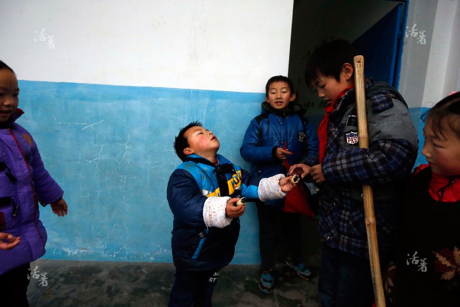 Mao Mao, a pre-schooler, gives half of his cookie to Zhuo Zijian, the oldest student in the school, after hearing that Zhuo didn't have breakfast that morning. [Photo/qq.com] 