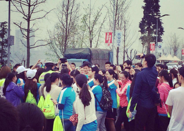 Runners rush to take photos of a policeman in Chongqing marathon, March 22, 2015. [Photo/qq.com] 