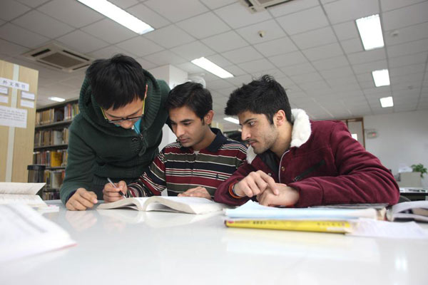 A university student from Pakistan (C) discusses with classmates at Northwest Polytechnical University in Xi'an, Shaanxi province, Dec 10, 2014. [Photo/Xinhua]
