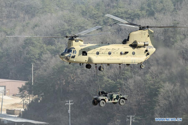 A cargo helicopter flies while it carries a military vehicle during the annual joint military exercise Foal Eagle between South Korea and the United States in Pocheon, northeast of Seoul, March 25, 2015.