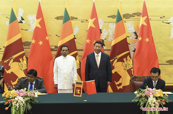 Chinese President Xi Jinping (2nd R) and Sri Lankan President Maithripala Sirisena (2nd L) attend a signing ceremony of cooperation documents after their talks in Beijing, capital of China, March 26, 2015.